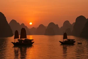 Ha Long Bay in Vietnam at sunset with traditional boats