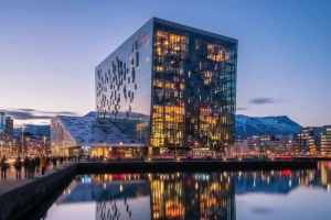 A photo of the Harpa Concert Hall in Reykjavik, with its unique glass facade reflecting the sky.