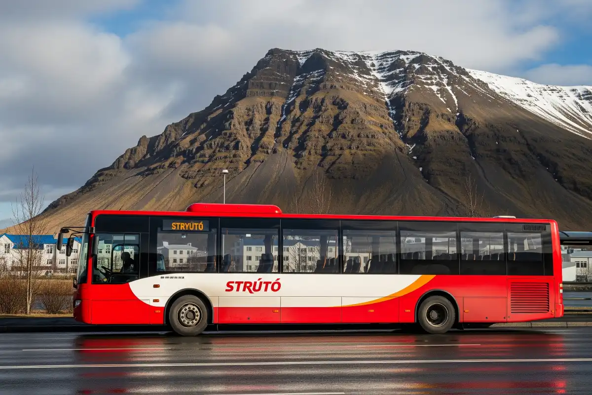 A photo of a local bus in Reykjavik with a scenic mountain backdrop.