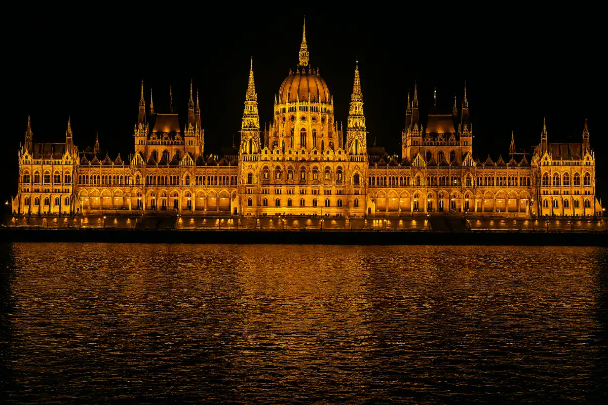A photo of the Hungarian Parliament Building lit up at night.