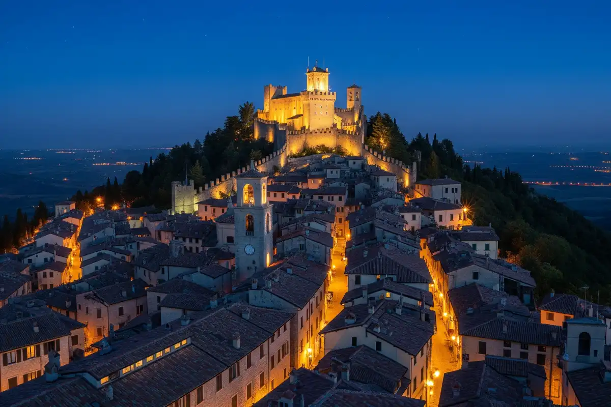 A photo of San Marino's historic city lit up at night.