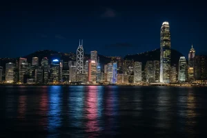 A photo of the Hong Kong skyline at night across Victoria Harbour.