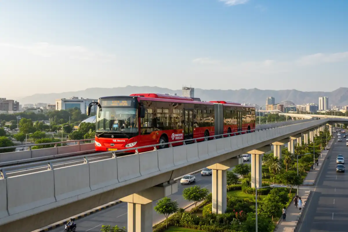 A modern, red Metro Bus traveling on a dedicated elevated track in Islamabad.