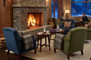 A cozy hotel lobby with a roaring stone fireplace and comfortable armchairs