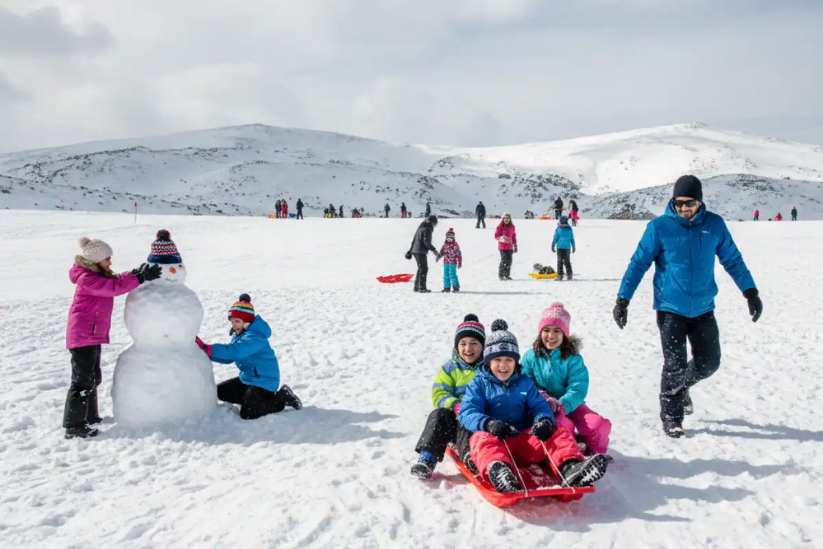 Families sledding and playing in the snow at the non-skiing area of Mount Hermon, Israel.