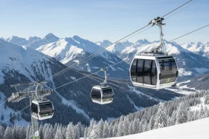 A modern, low-impact gondola lift powered by green energy ascends a mountain slope in the European Alps, with untouched snow and healthy tree lines visible below, highlighting sustainable mountain infrastructure.