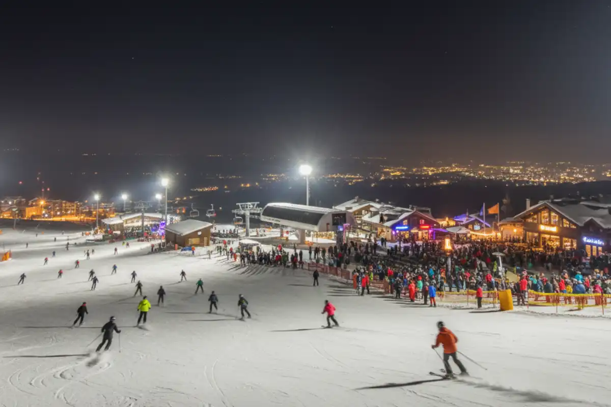 Night skiing in the Sierra Nevada resort with illuminated slopes and a lively atmosphere.