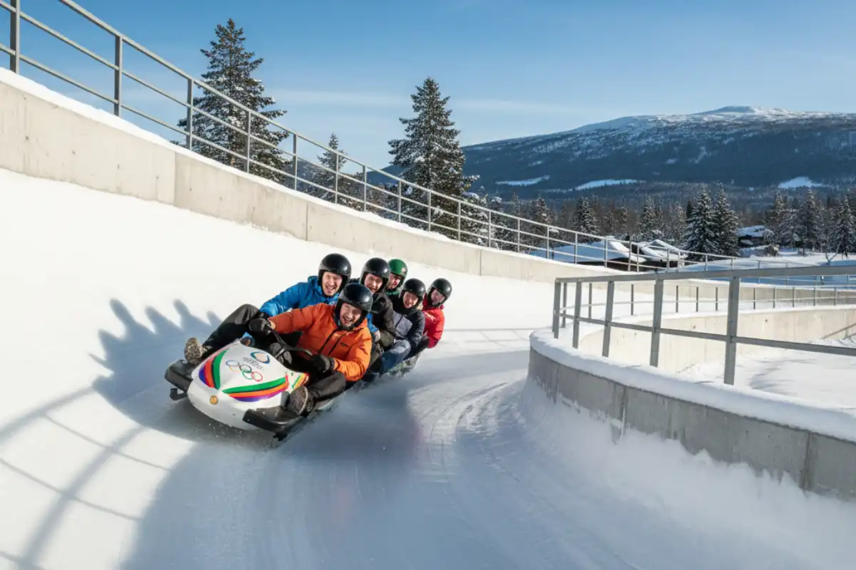A group of people enjoying a thrilling bobsleigh ride down the Olympic track near Lillehammer, Norway.
