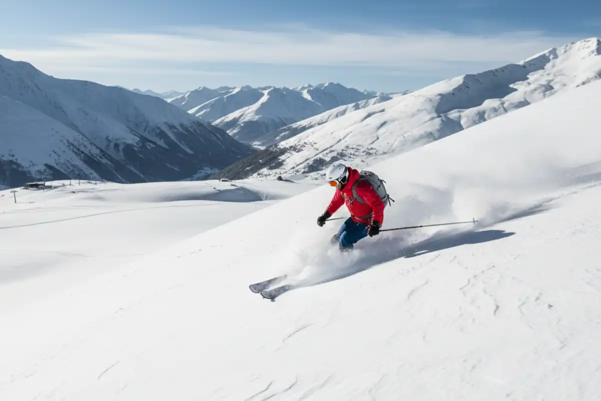 A skier mid-turn on a vast, untracked freeride slope in Gudauri, highlighting the off-piste potential.