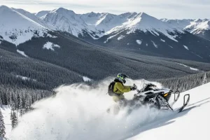 A powerful snowmobile kicking up a huge cloud of fresh powder as it ascends a steep, untracked mountain slope in the Rocky Mountains.