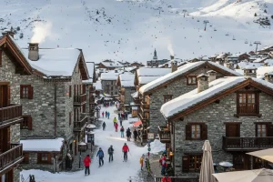 Val d’Isère village showing the traditional stone and wood architecture with ski slopes visible.