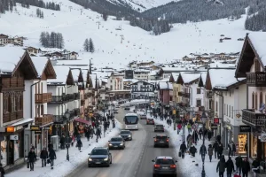 The wide, snow-covered valley of Livigno with the main street, shops, and ski slopes visible in the background.