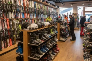 Various pairs of skis and boots neatly organized on racks in a well-stocked rental shop