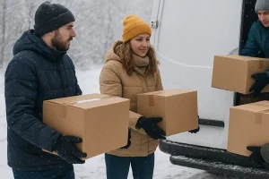 Volunteers bundled up in jackets loading boxes of supplies on a snowy winter day