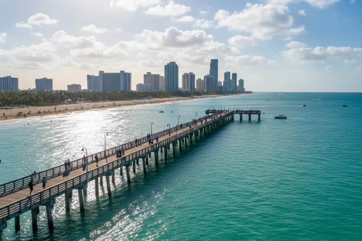 A long wooden pier stretching into the clear blue Atlantic at South Pointe Park during a sunny morning