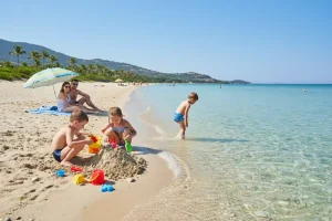 Children playing with sand toys on a tranquil, crystal-clear shoreline