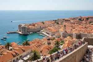 The terracotta-roofed limestone buildings of Dubrovnik Old Town surrounded by massive medieval stone walls and the shimmering turquoise Adriatic Sea