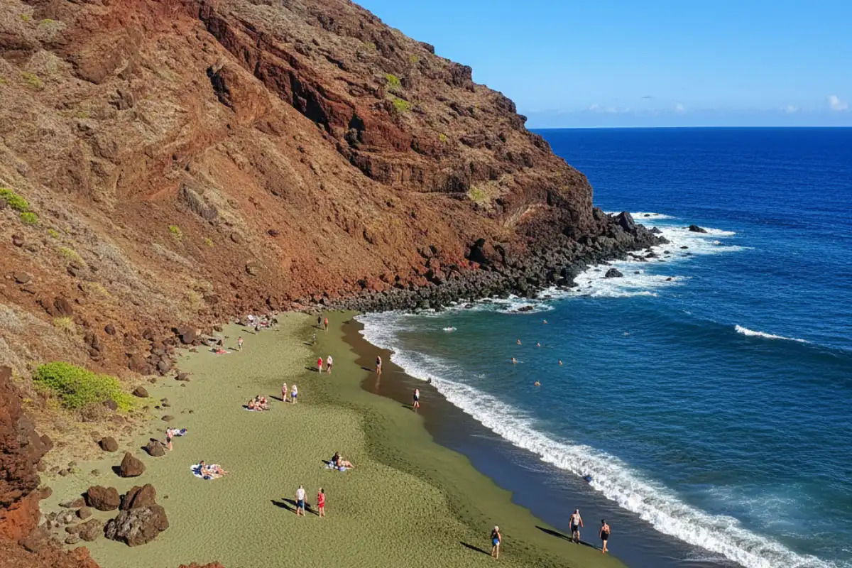 The steep slopes of a volcanic cinder cone leading down to the olive-green crystals of Papakolea Beach under the bright midday sun